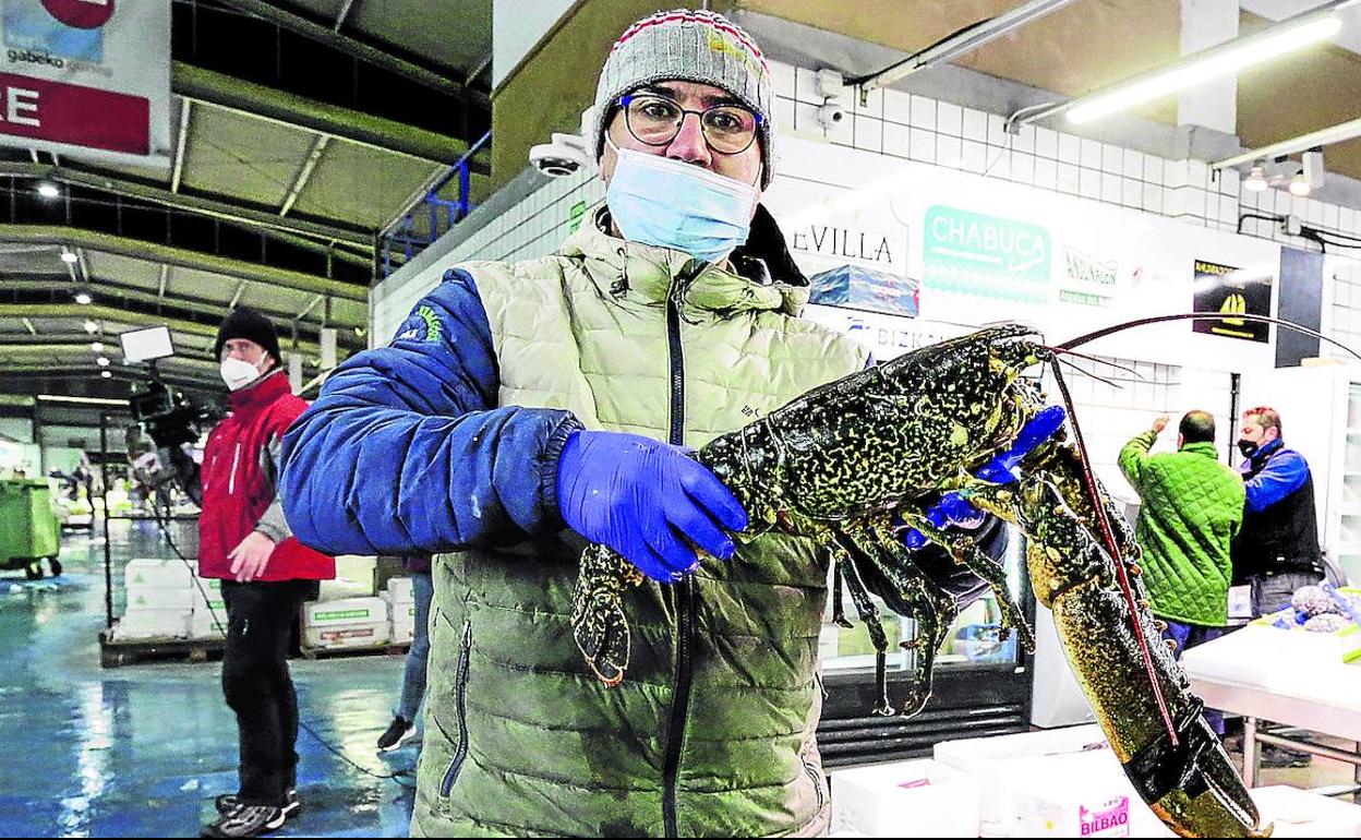 Un pescatero muestra orgulloso el tamaño de este magnífico bogavante, de más de cinco kilos de peso.