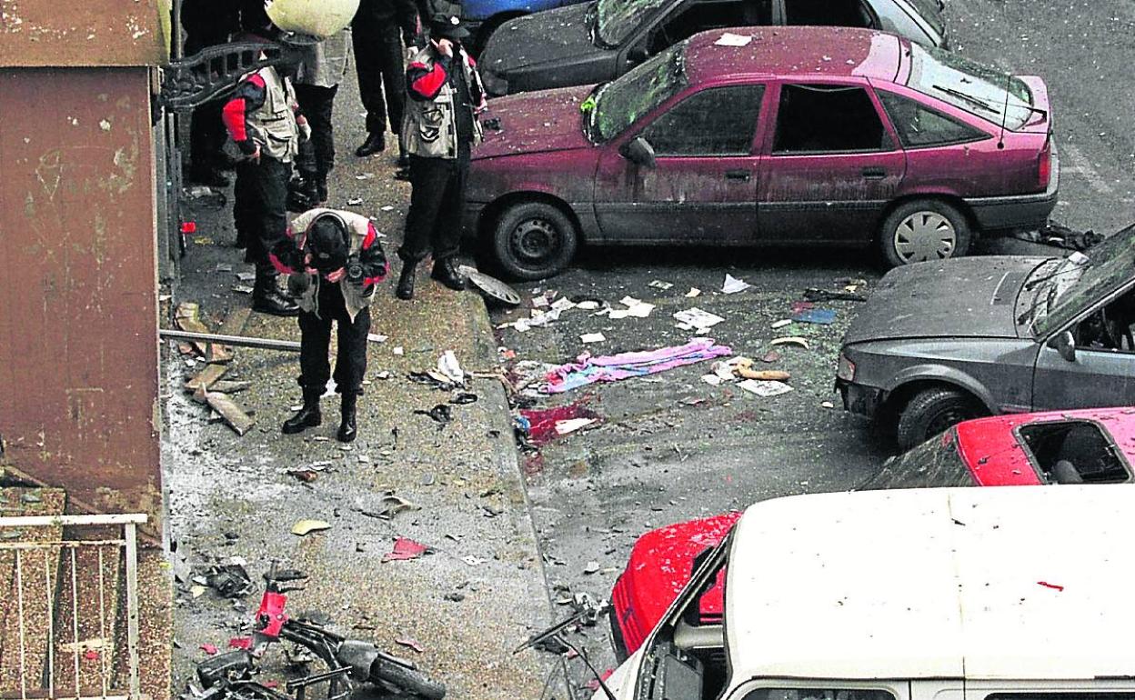 Agentes de la Ertzaintza inspeccionan el lugar donde estalló la moto bomba que asesinó a Zamarreño en 1998. 