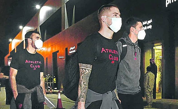 Imagen principal - Arriba, los rojiblancos llegaron ya de noche a la capital saudí. Abajo, a la izquierda, los jugadores ocuparon las primera filas del avión. A la derecha, Nico Williams se dirige al autobús que les llevaría hasta el hotel en el que se hospedarán en Riad.
