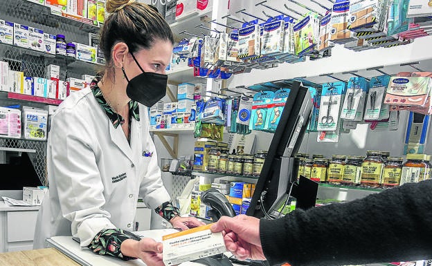 Una farmacéutica vende un test de antígenos.