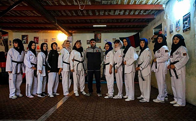 Imagen principal - Las deportistas junto a su entrenador, Nematullah Habibi. 