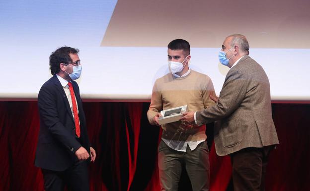 Jon Agiriano entrega el trofeo a Iker Bilbao, jugador, y Jon Larrea, presidente del Amorebieta.