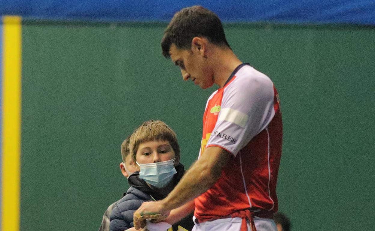 Urrutikoetxea le da la muñequera a un niño tras un partido.