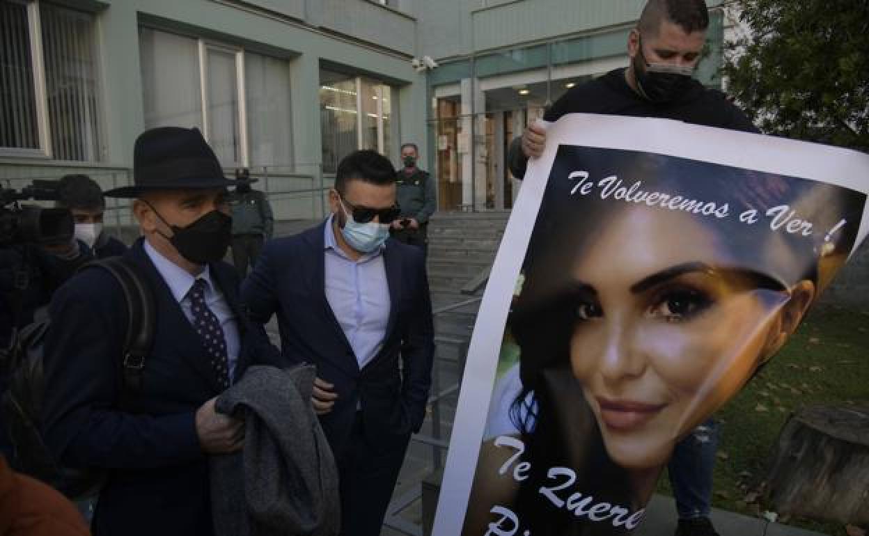 Familiares de la víctima enseñan un cartel con su cara ante el cirujano que la operaó.