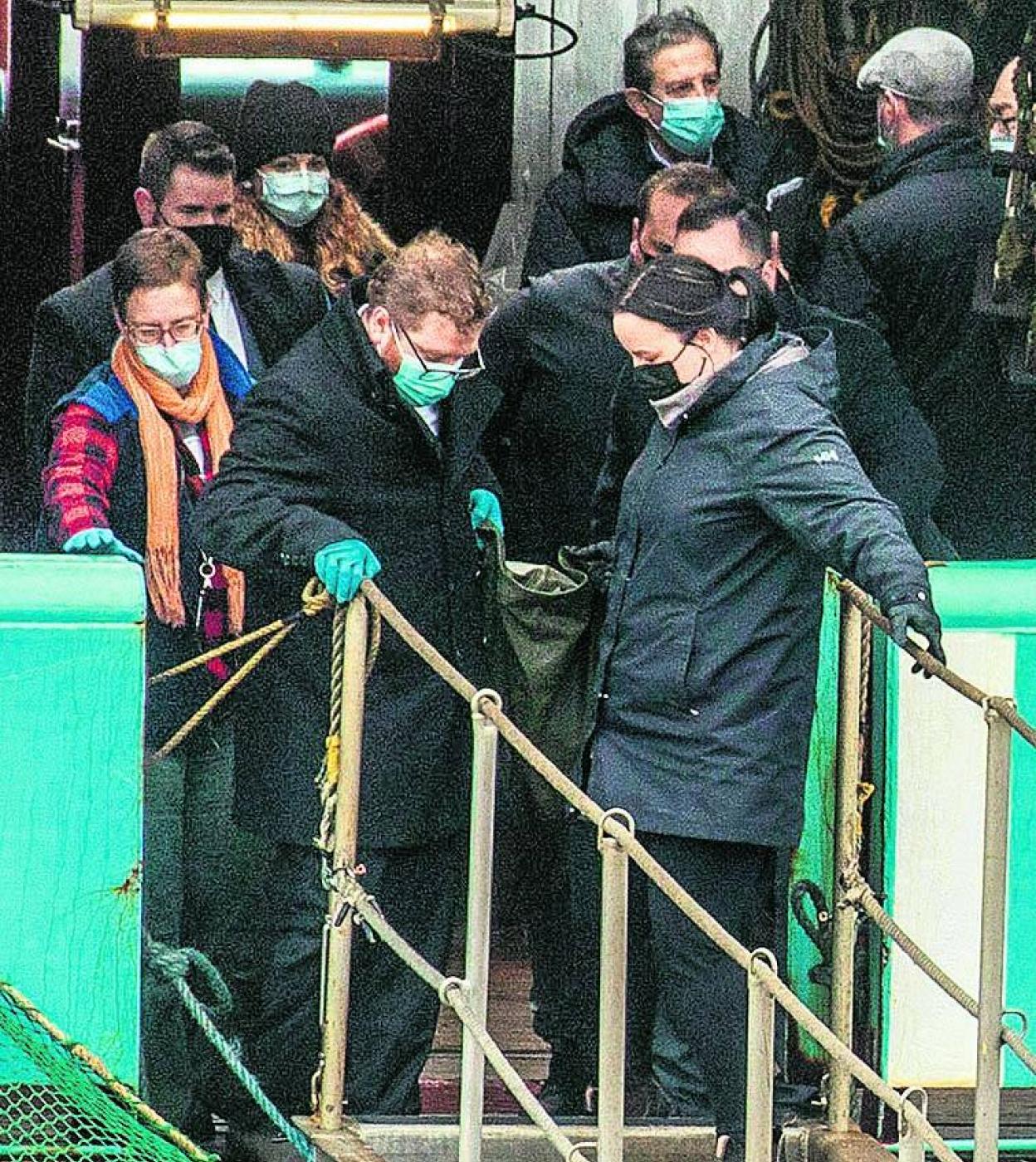 Forenses trasladan uno de los cadáveres. 