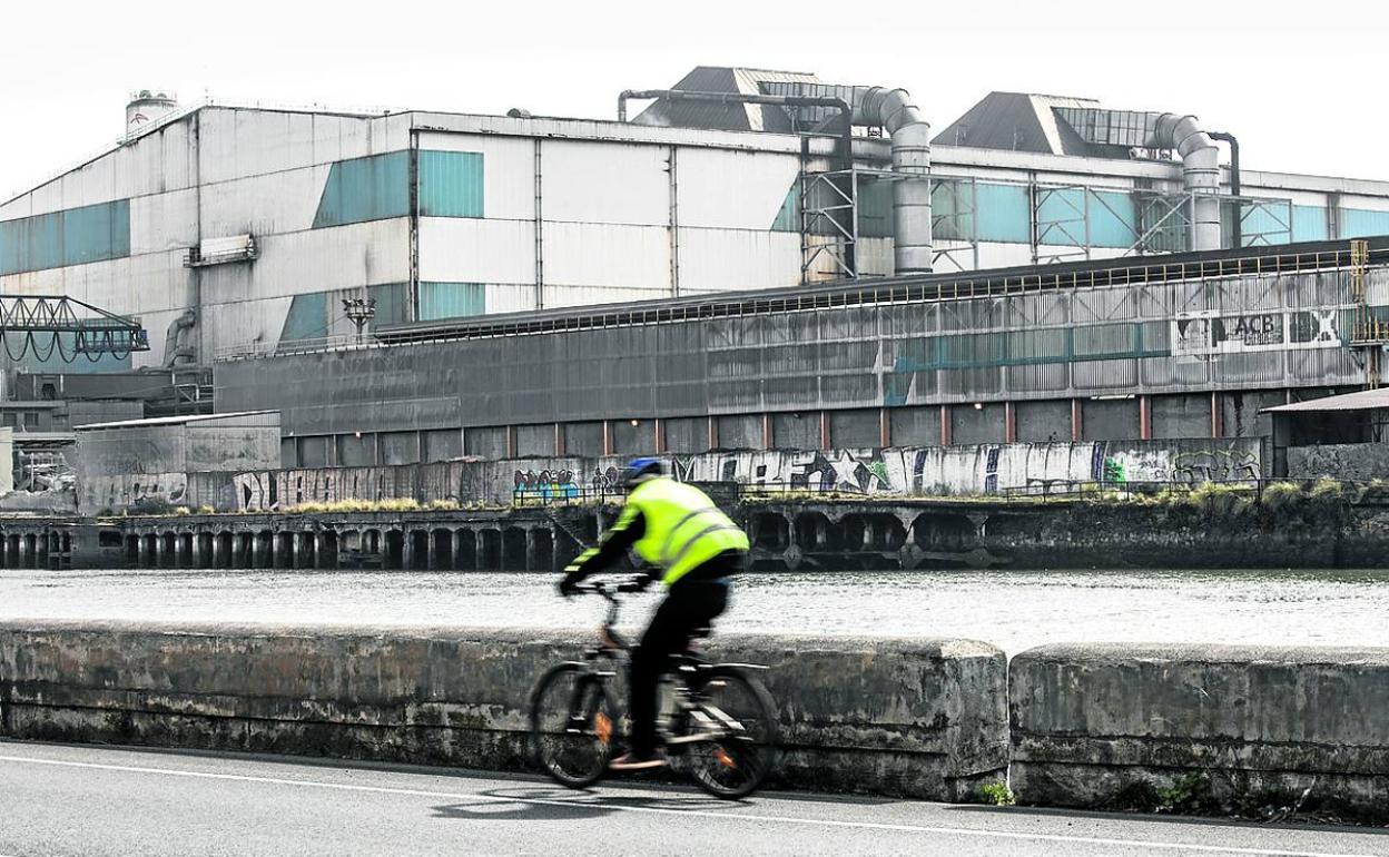 Un ciclista pasa ante la planta de Sestao. 