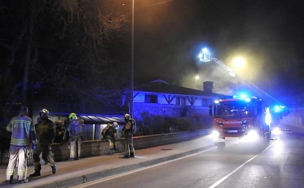 Los bomberos elevan una escala para ver el estado del tejado. 