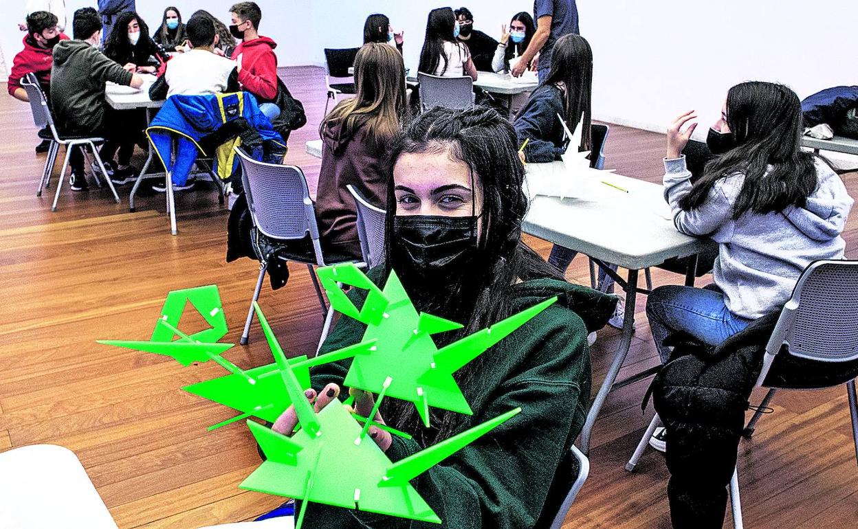 Una chica muestra la figura que ha creado a partir de las piezas en miniatura de la escultura 'Azares', de Esaú de León. 