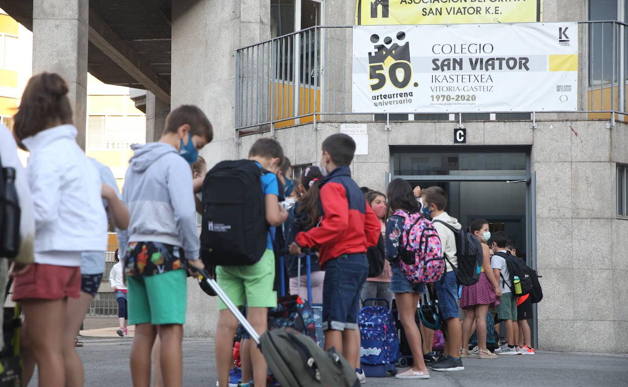 Un grupo de estudiantes aguarda para entrar a un centro concertado de Vitoria. 