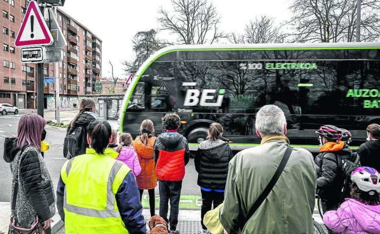 Las familias se agolpan en la mediana esperando a que pase el BEI para terminar de cruzar la calle. 