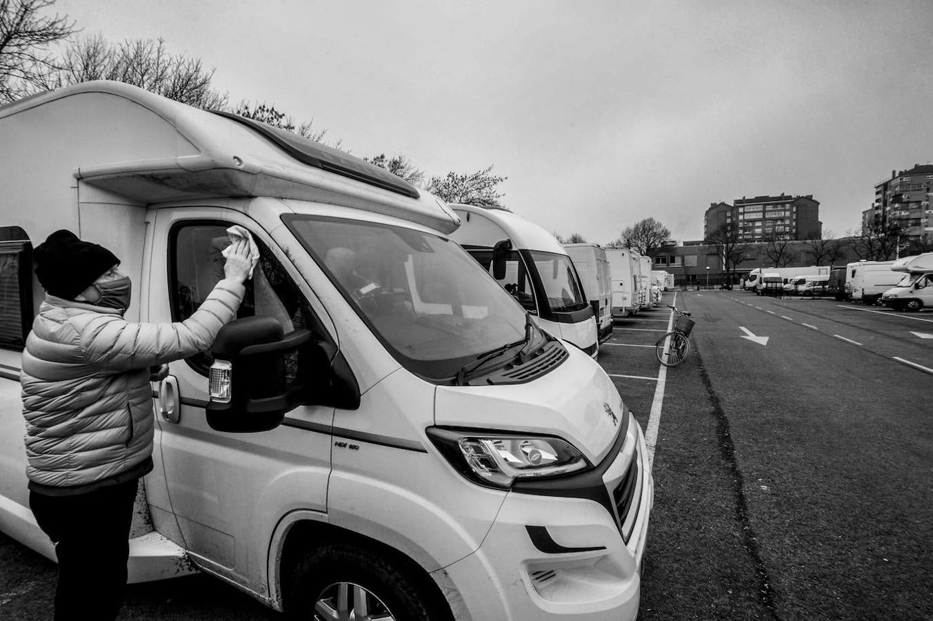 El británico Harry Jones limpia su caravana en el parking, que una vez a la semana comparte espacio con el mercado ambulante, antes de continuar su viaje hacia Málaga.