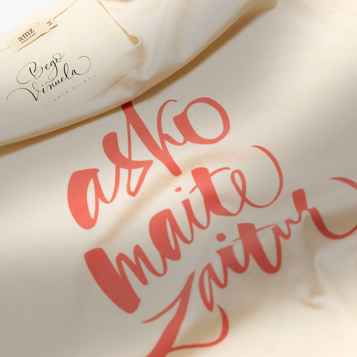 Ya sabemos la teoría: hay que decir ‘te quiero’ todos los días. Pero si aparte se lo pones a tu ama por escrito con la preciosa caligrafía de Bego Viñuela y lo estampas en una camiseta como las que ha creado amz Magic Stories, tenemos como resultado el regalo perfecto. Una sinergia de creatividad con las palabras mágicas escritas en euskera: “asko maite zaitut”. Precio: 31 euros, a la venta en su página web.
