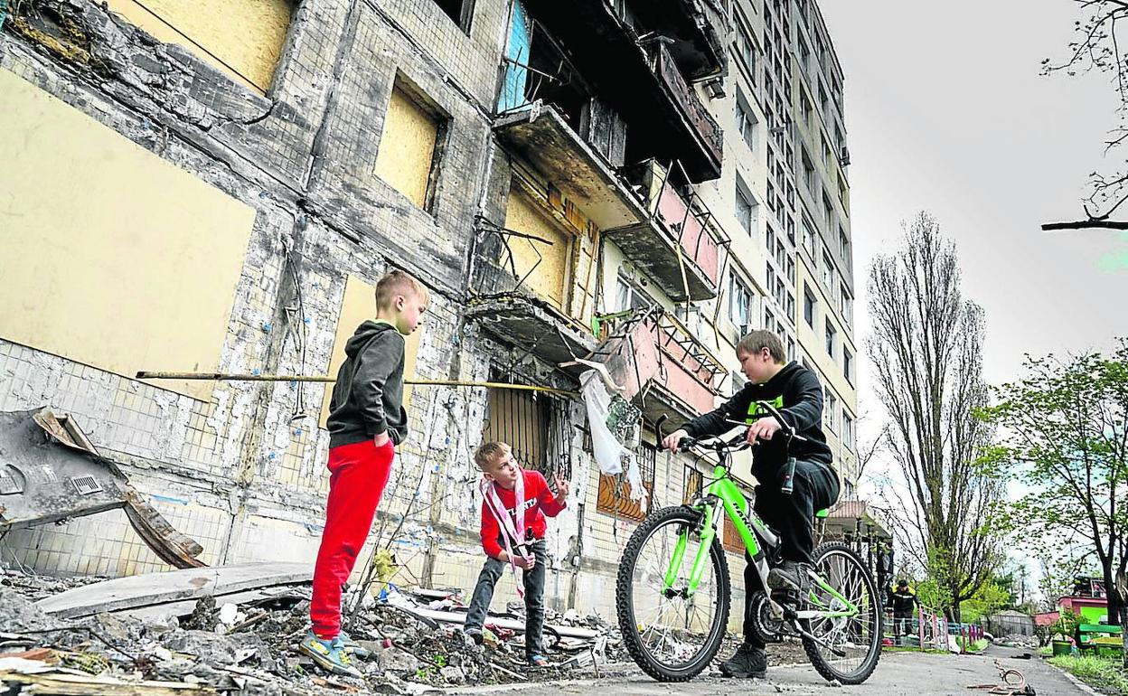 Vario niños juegan entre los escombros de un edificio atacado con un misil en el distrito de Obolon