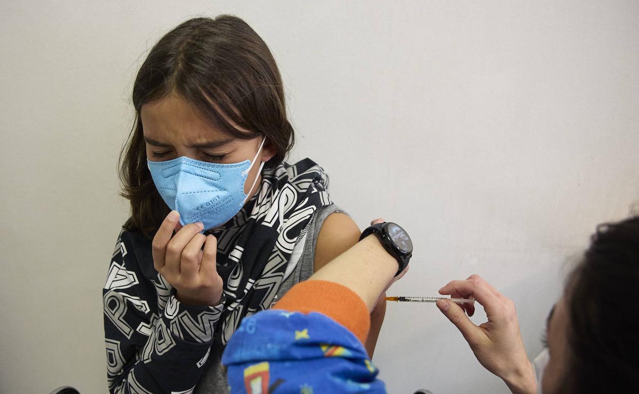 Médicos vacunan a una niña