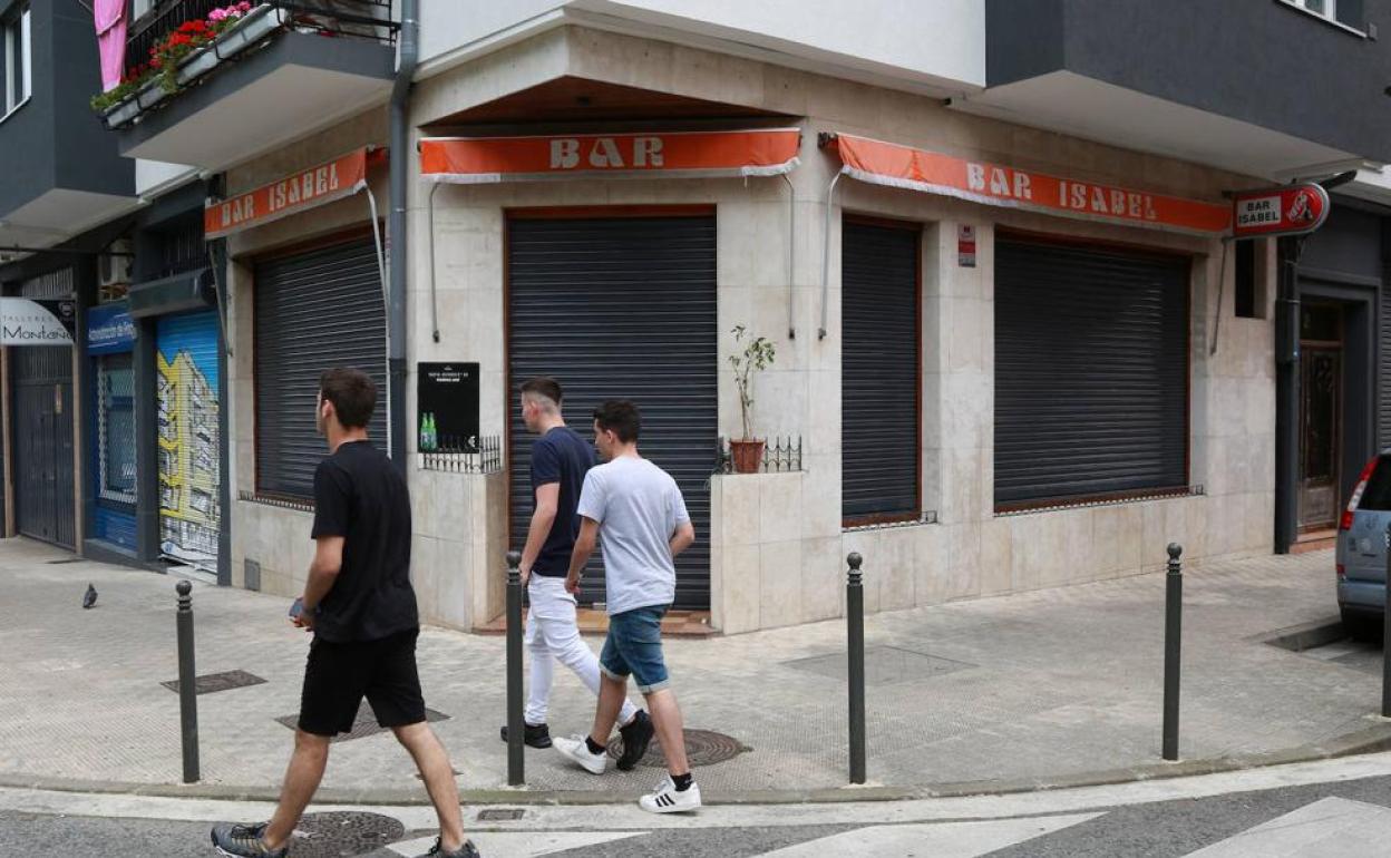 Tres jóvenes pasan ante el local donde el detenido ayudó a su suegra en Irun. 