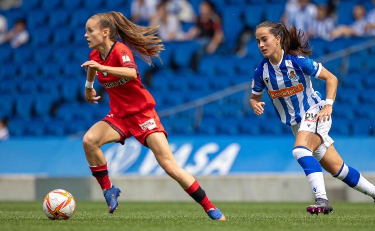 Carla Armengol conduce la pelota ante Nuria Rábano, jugadora de la Real. 