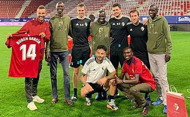 Los corredores keniatas posan con jugadores de Osasuna en El Sadar.