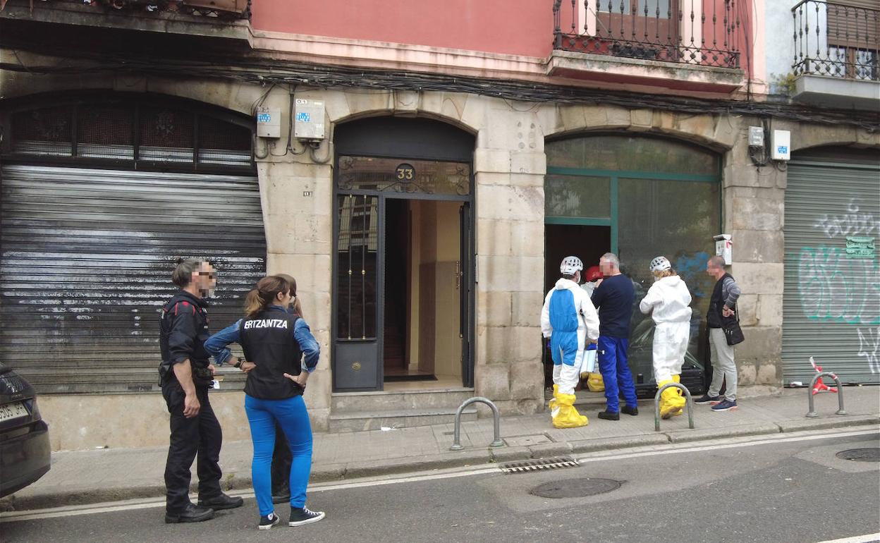 Agentes de la Policía Científica, con buzos, acceden al interior de la lonja incendiada en Atxuri.