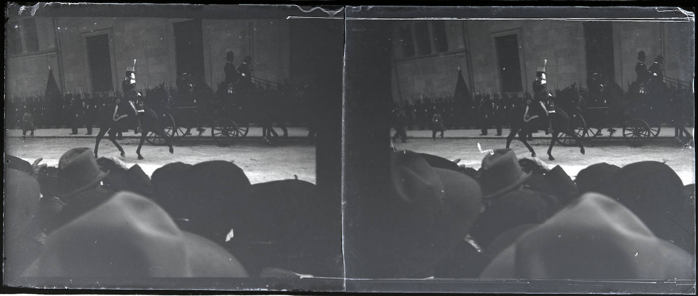 El público y las tropas militares asisten al desfile de la comitiva del rey Alfonso XIII a su paso por la calle Becerro de Bengoa