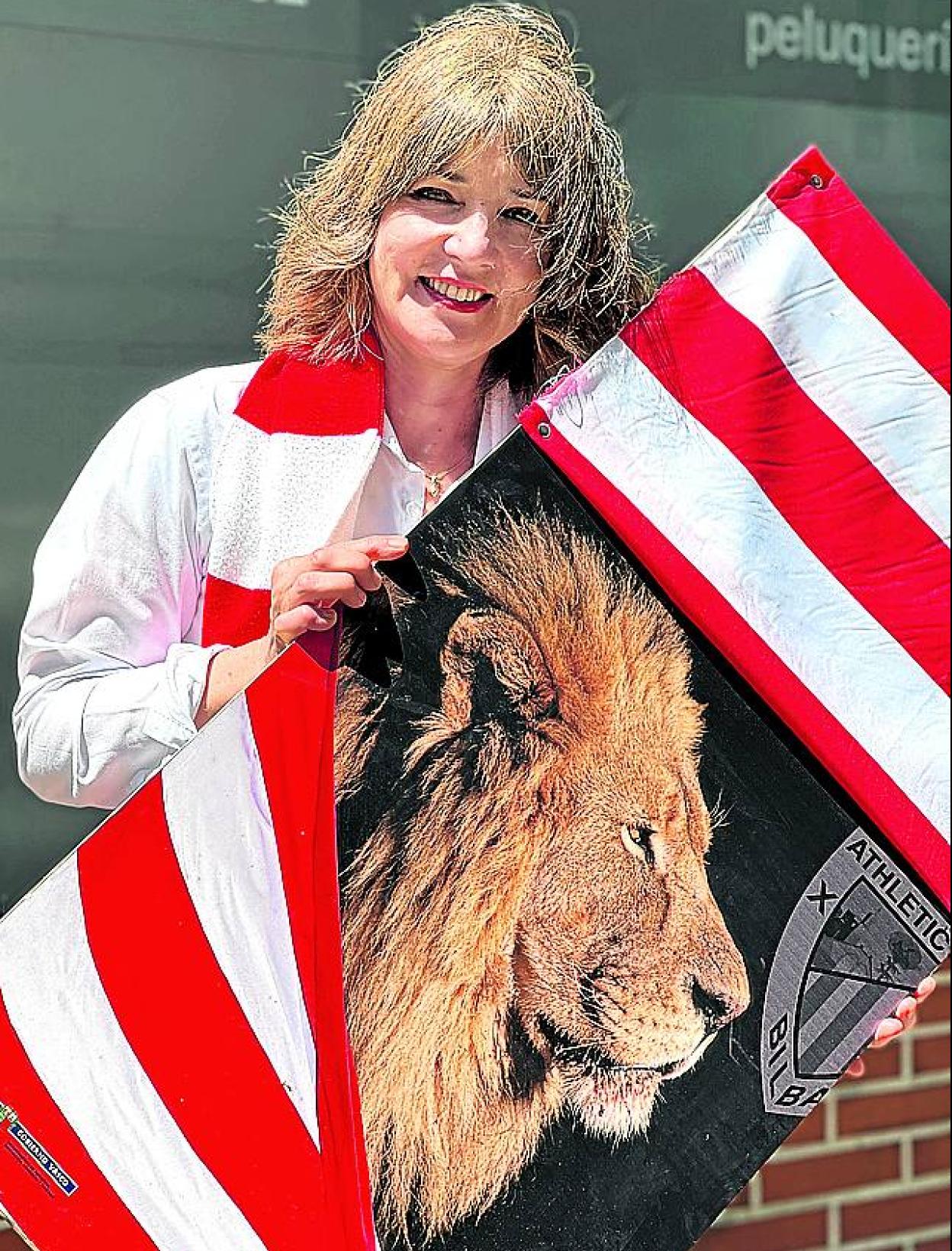 Begoña Méndez posa con un cartel del Athletic delante de su negocio en Santurtzi. 