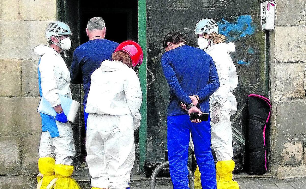 Agentes de Policía Científica registran la lonja incendiada en busca de pruebas. 