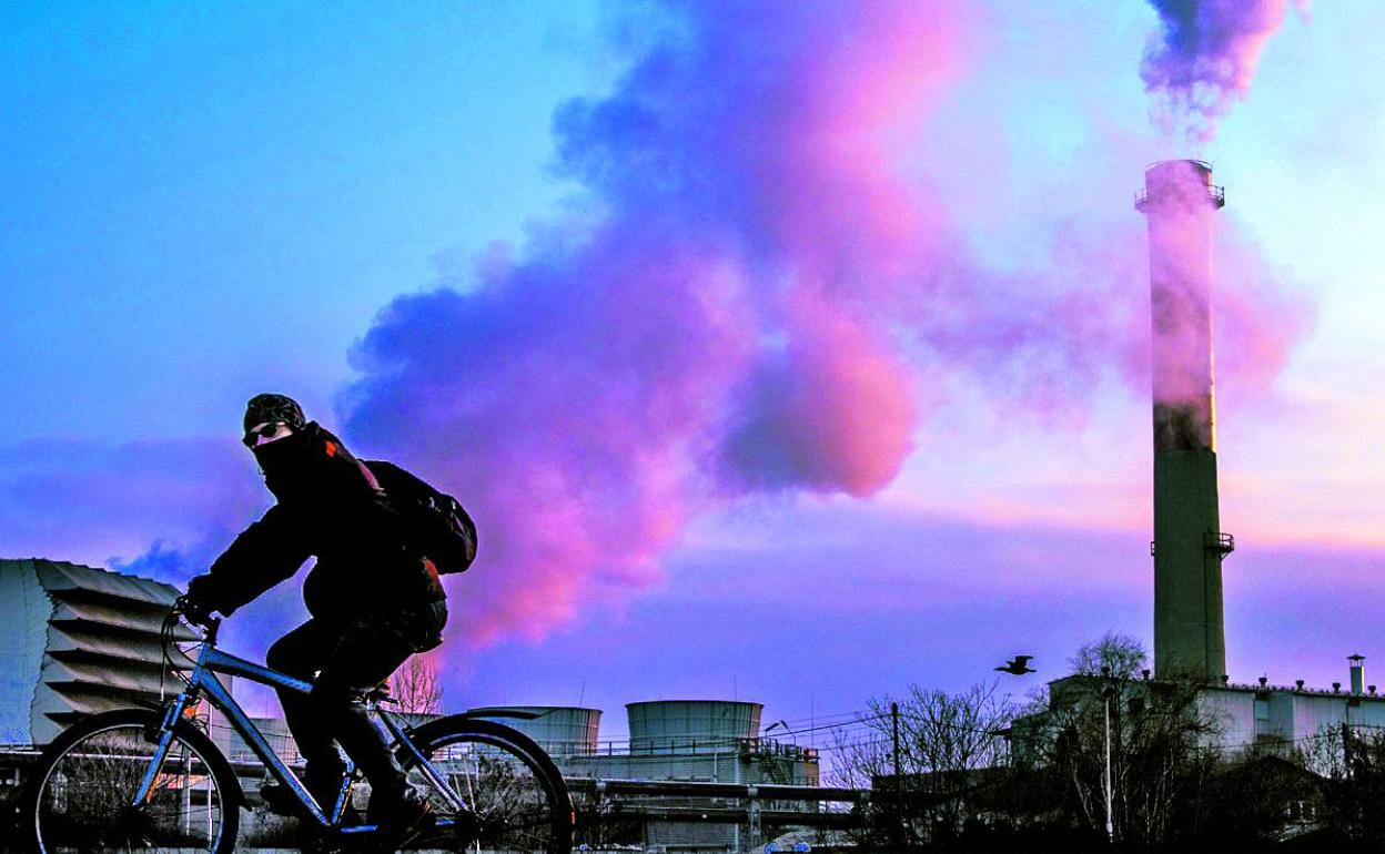 Un hombre pasea en bicicleta frente a la central nuclear de Skopie, en Macedonia. 