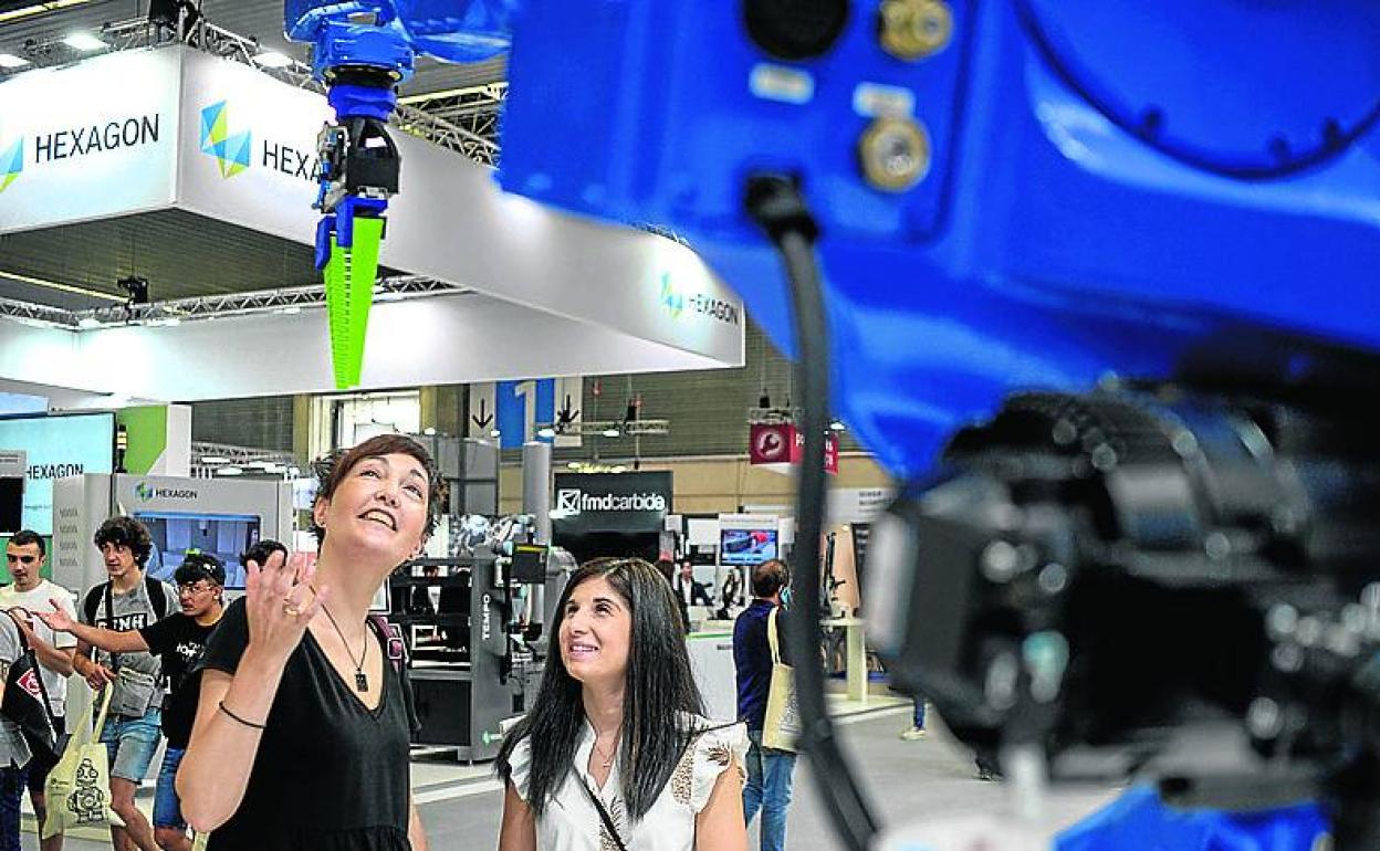 Dos mujeres observan una de las máquinas expuestas en la Bienal. 