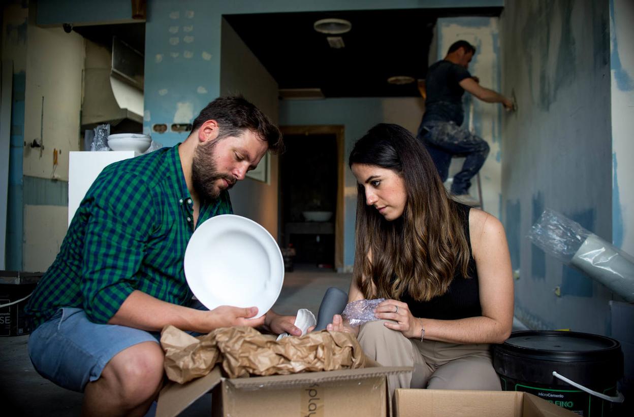 La administrativa Nerea Zubiaur (33) y el cocinero Julen Bergantiños (32) trabajan en lo que será sala de Islares mientras Constantin Chiruta luce una pared de la cocina.