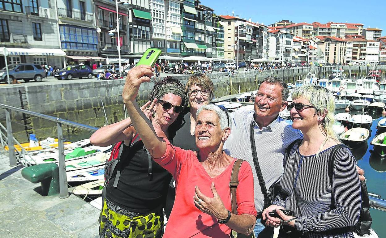 Un grupo de turistas se fotografía en el puerto de Lekeitio. 
