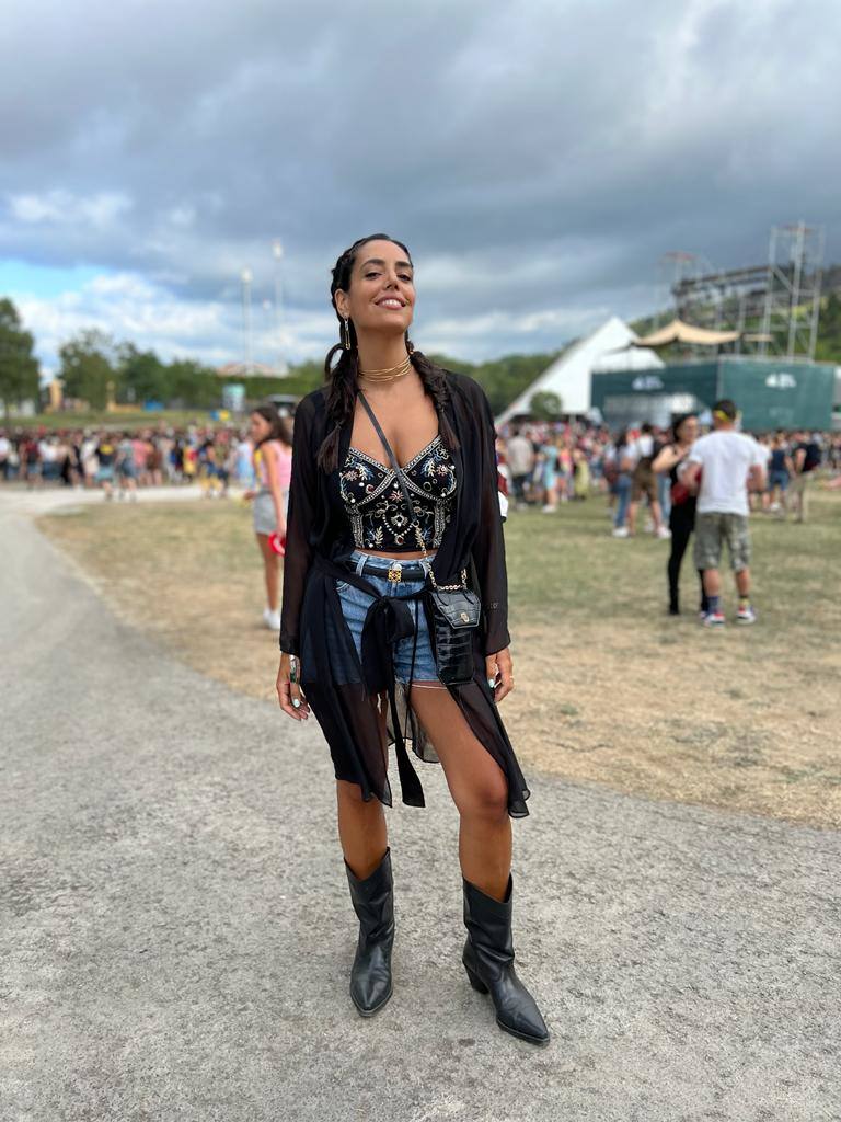 Naiara Arévalo viene de Gorliz con un look festivalero nivel experto: shorts vaqueros de Levi´s, kaftán de estética bohemia de Intimissimi que contrasta con el top lencero con aplicaciones de Zara. Completa su estilismo con unas infalibles botas de estilo 'cowboy' y un bolso de piel grabada de Maje.