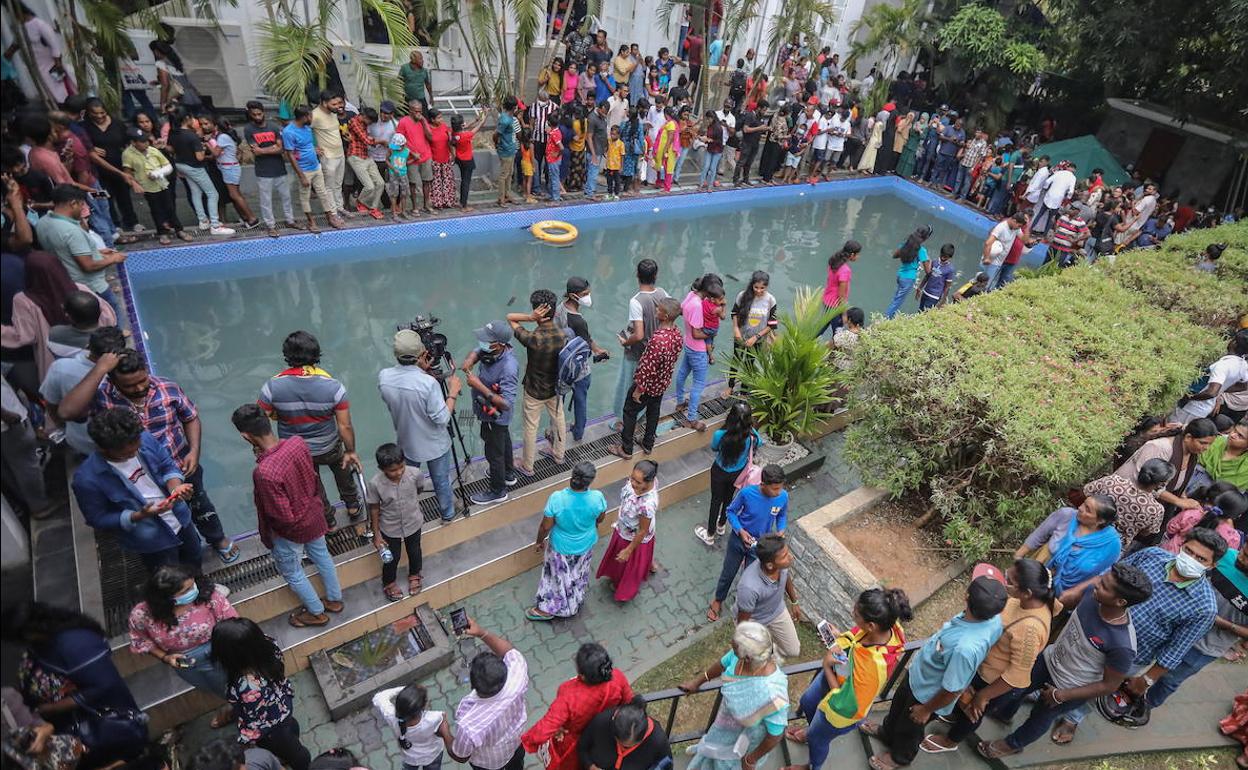 Cientos de personas reunidos alrededor de la piscina del palacio presidencial tras el asalto.