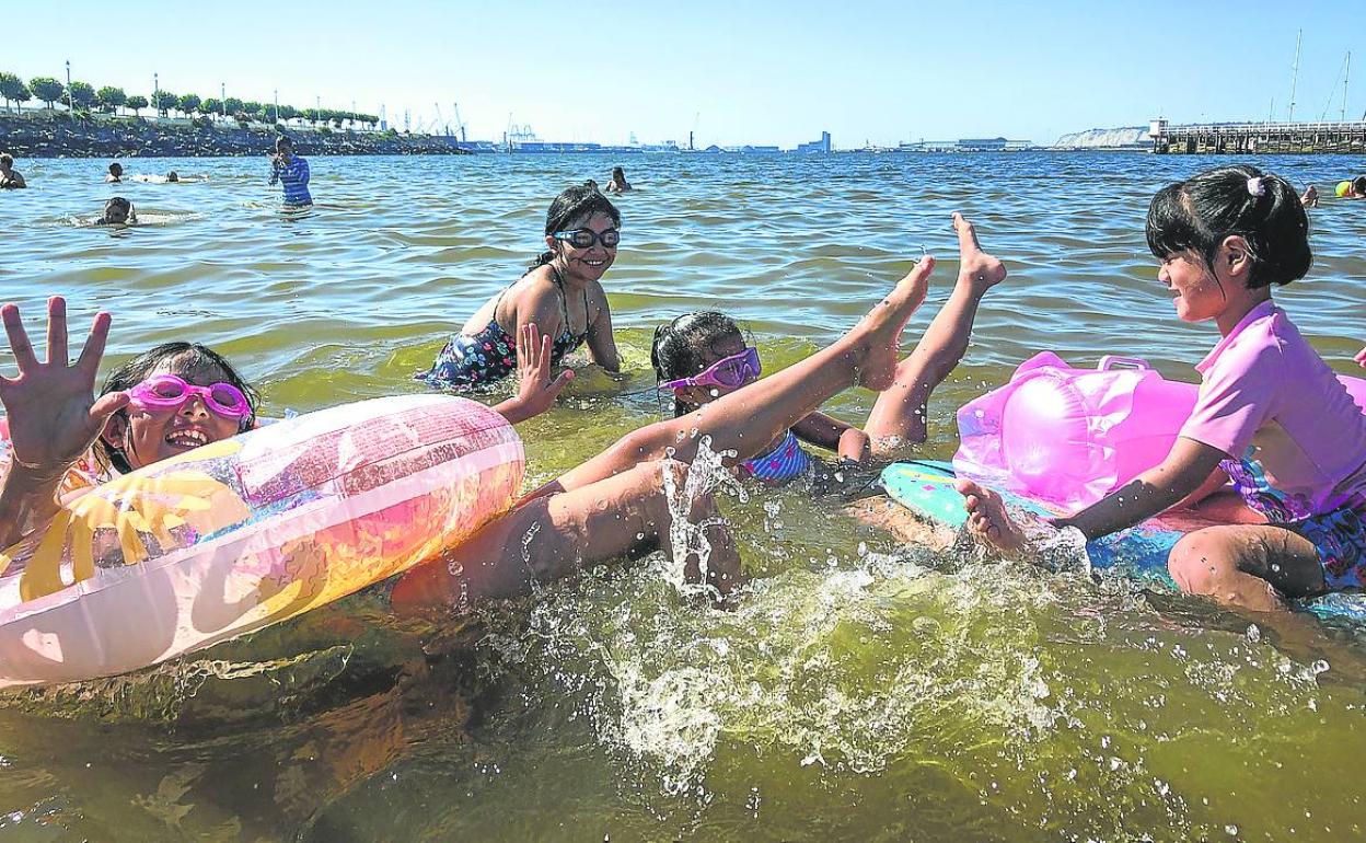 Un grupo de niñas se da un chapuzón en la playa de Las Arenas. 