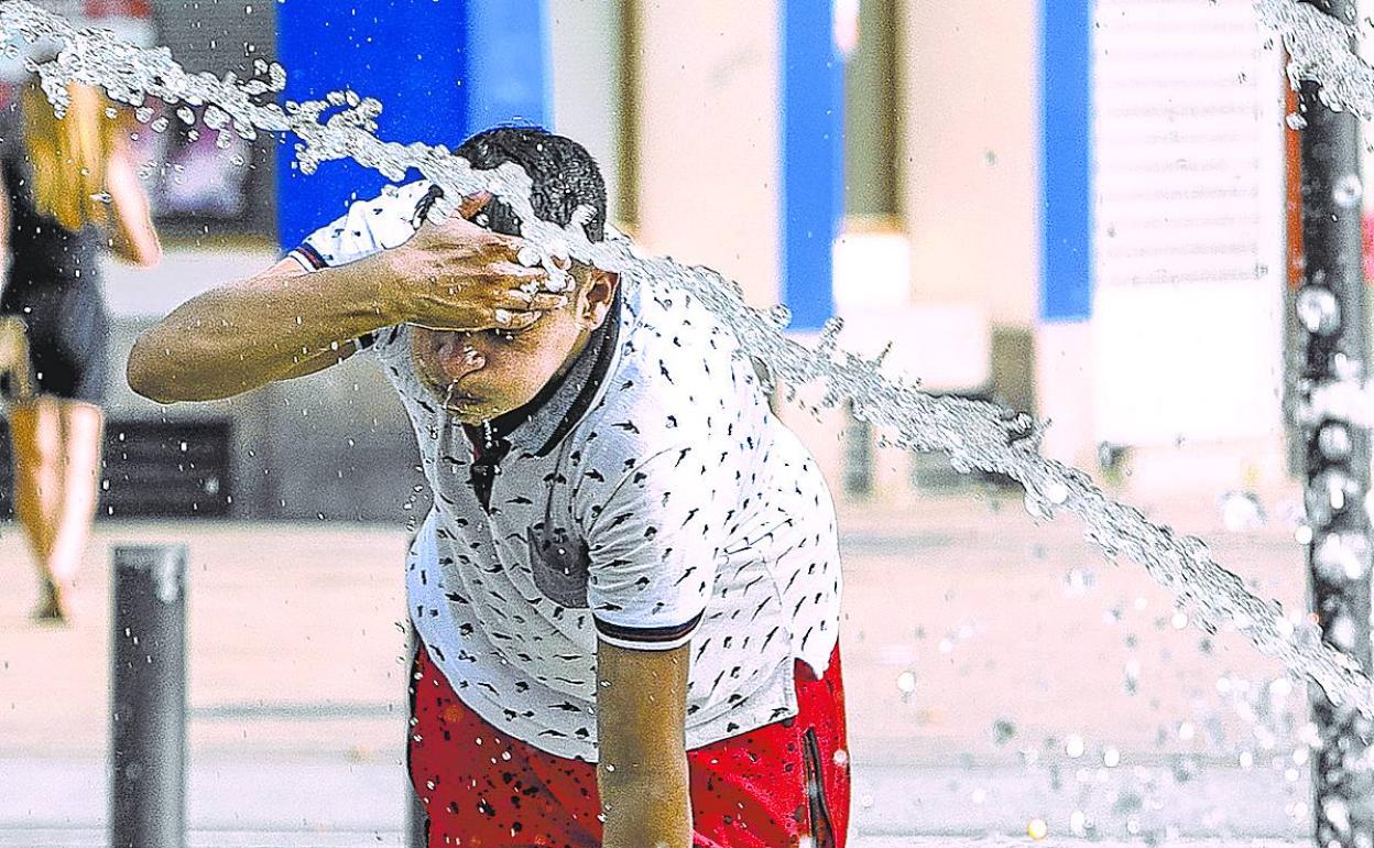 Un joven se refresca en una fuente en la capital alavesa. 