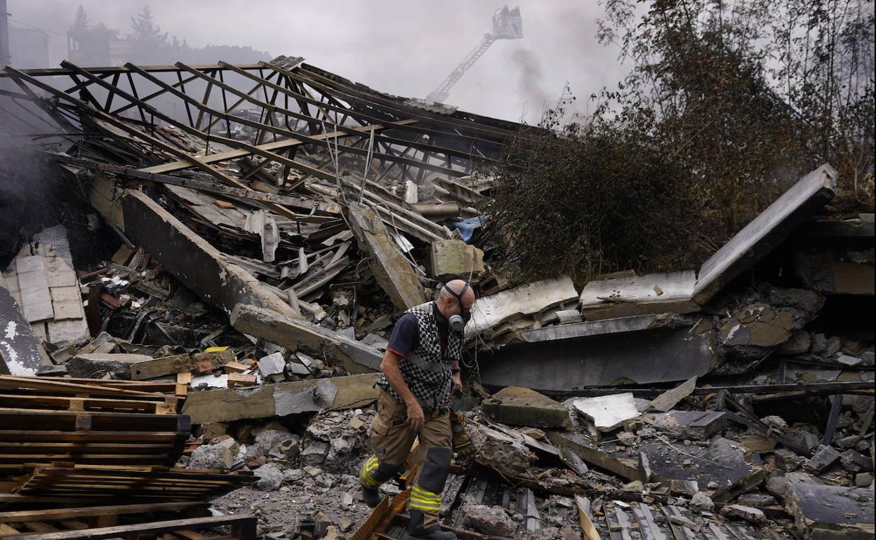 Un bombero camina sobre los restos del edificio derrumbado por el incendio.