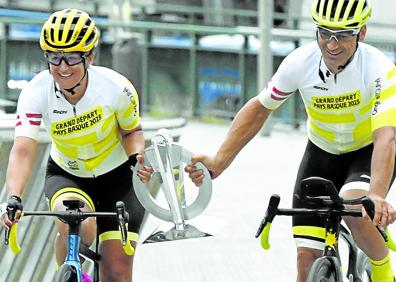 Imagen secundaria 1 - Juan María Aburto y Unai Rementeria posan con los ultrafondistas que trajeron el trofeo del Tour desde París en el Museo Guggenheim. Arriba, Ziortza Villa y Julián Sanz, con el testigo de la Grande Boucle en los últimos metros de su aventura a su llegada a Bilbao. A la derecha, la corredora se funde en un abrazo en la 'meta' de la villa.