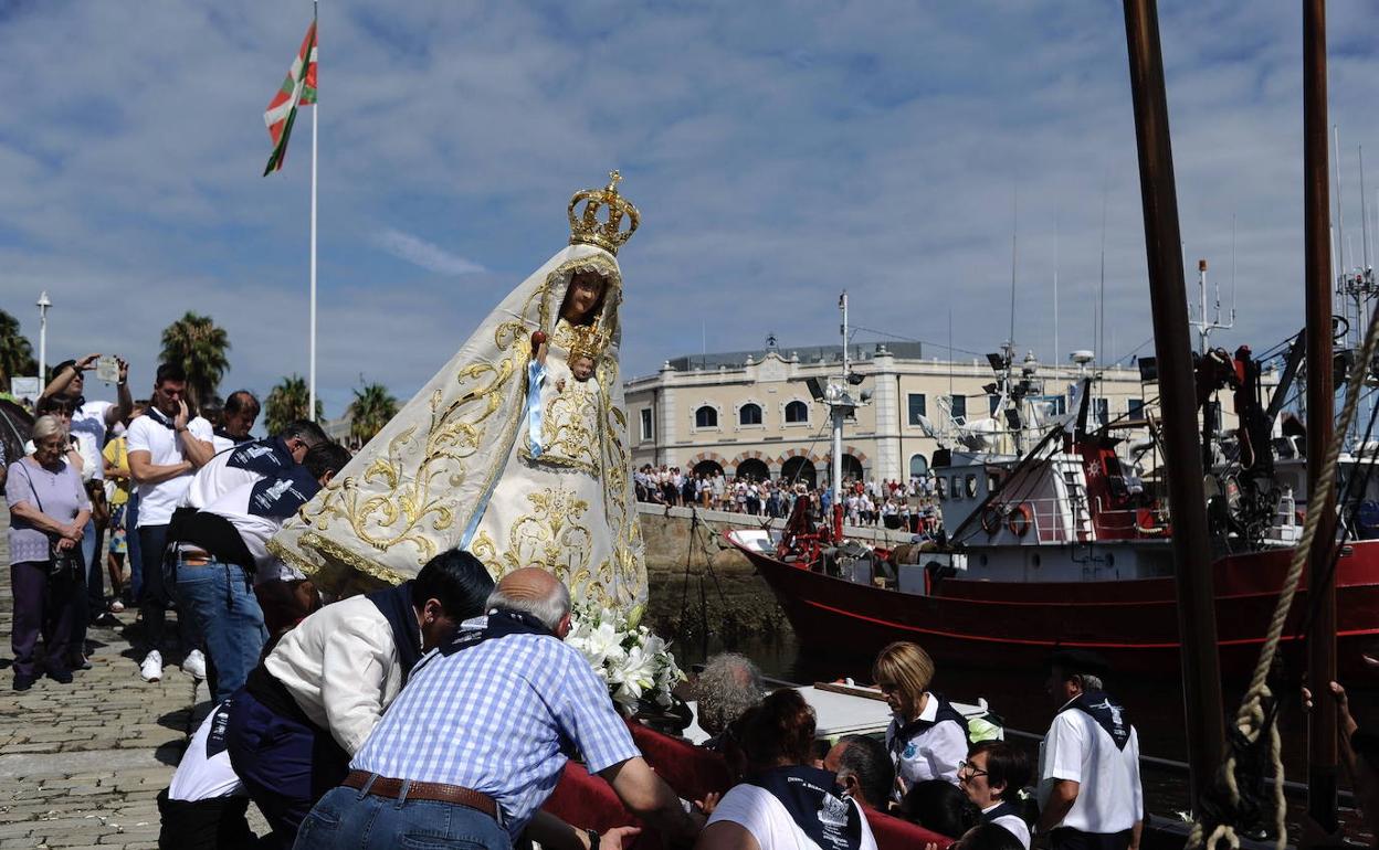 Los cofrades colocan a la Virgen de Begoña en su embarcación durante la procesión de 2019. 