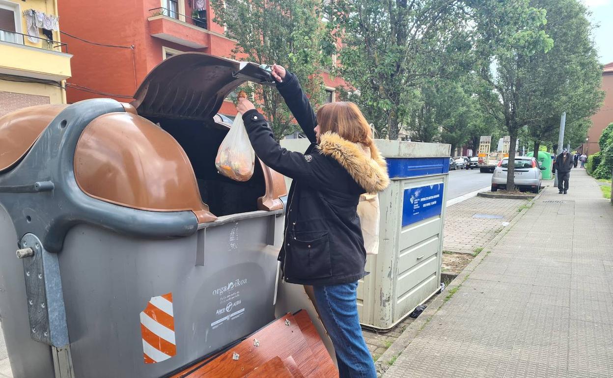 Una mujer recicla una bolsa de basura orgánica en un contenedor específico situado en Llodio. 