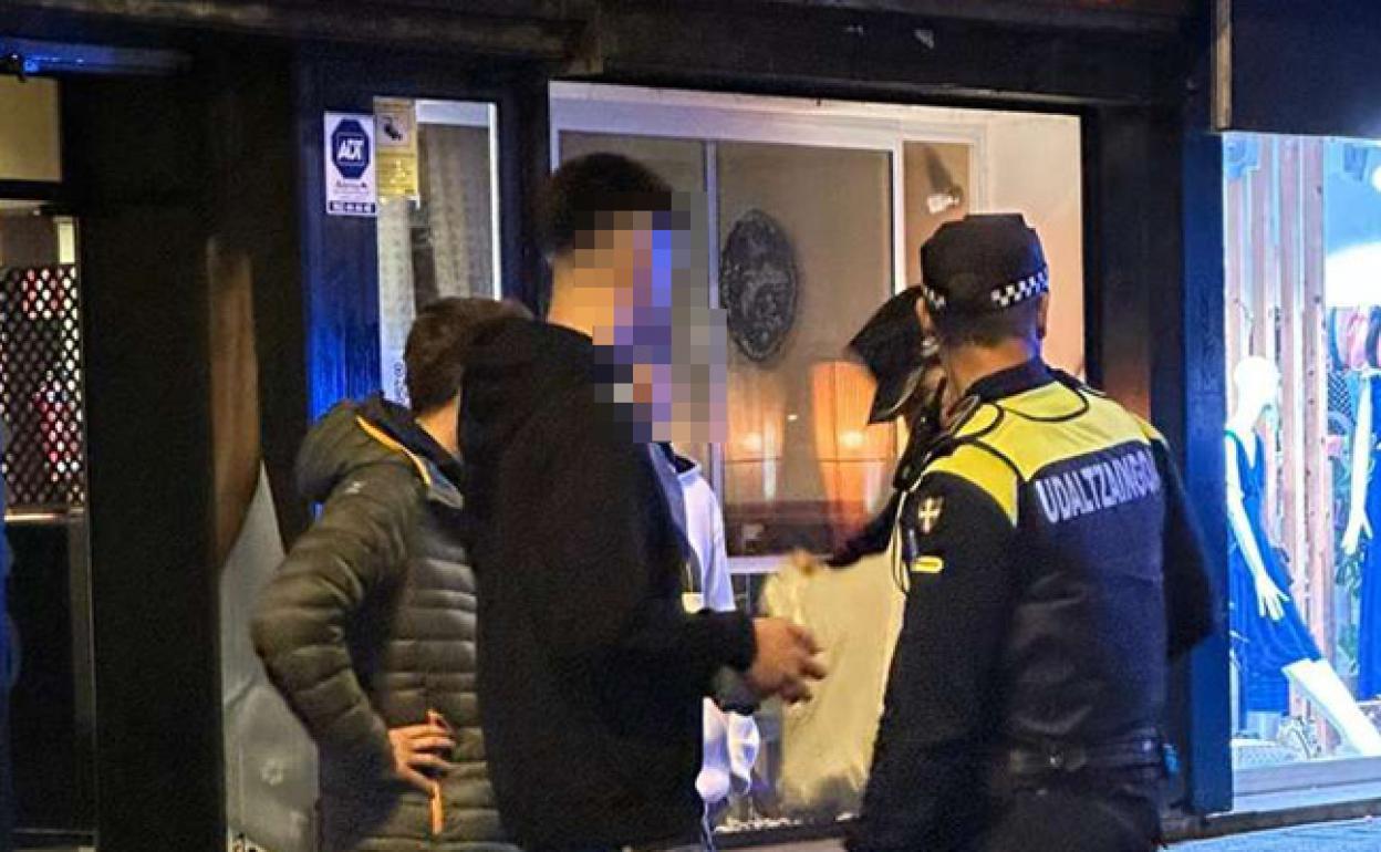 Varios agentes revisan las bolsas de unos jóvenes junto a la estación del metro. 