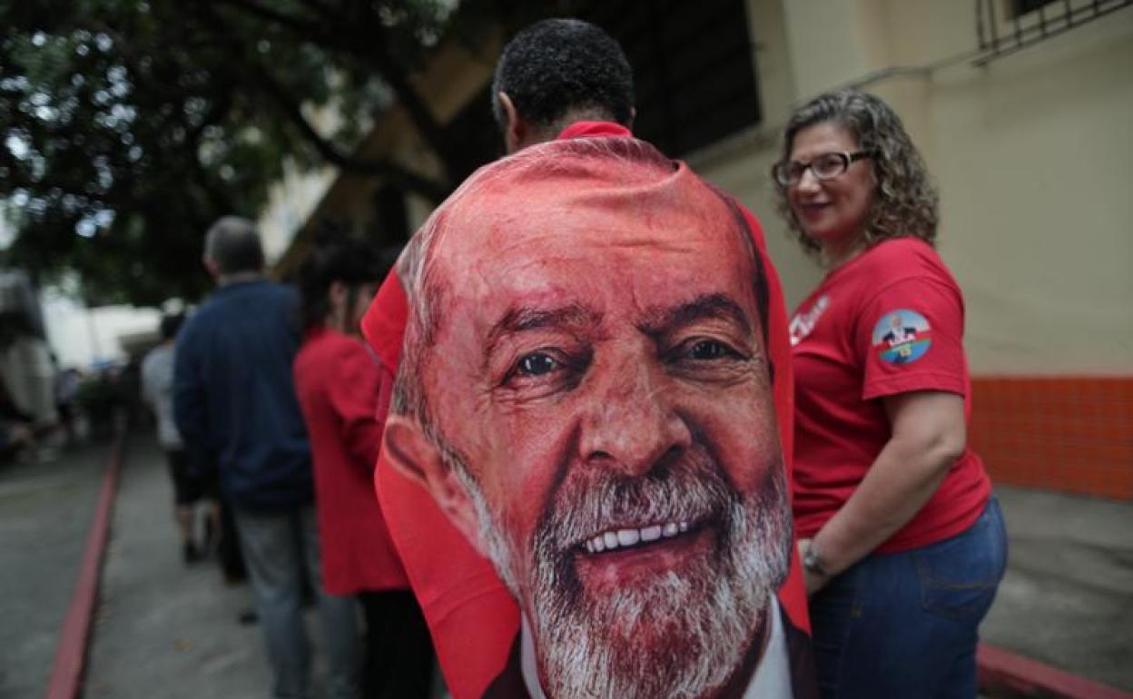 Una mujer exhibe una pancarta de tela con el rostro de Lula. 