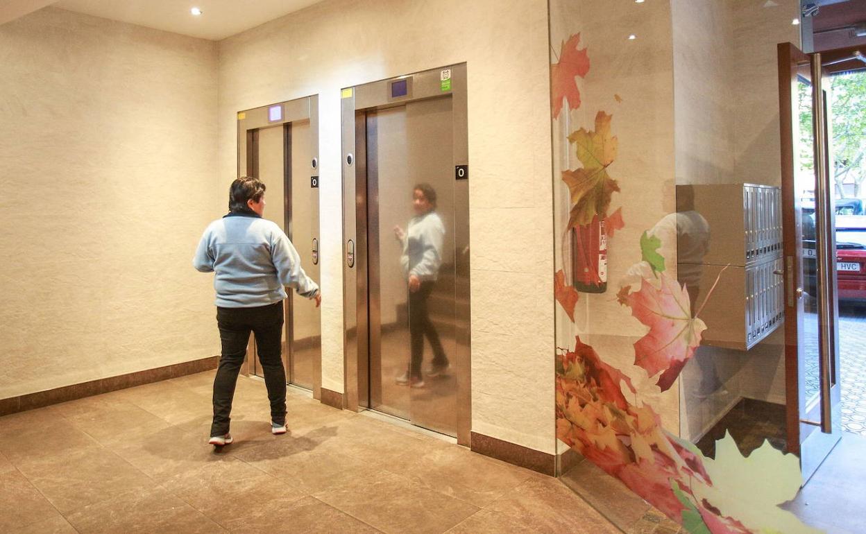 Una mujer ajena a los hechos llama al ascensor donde Pilar Arbulo fue atacada el 12 de mayo de 2019. 