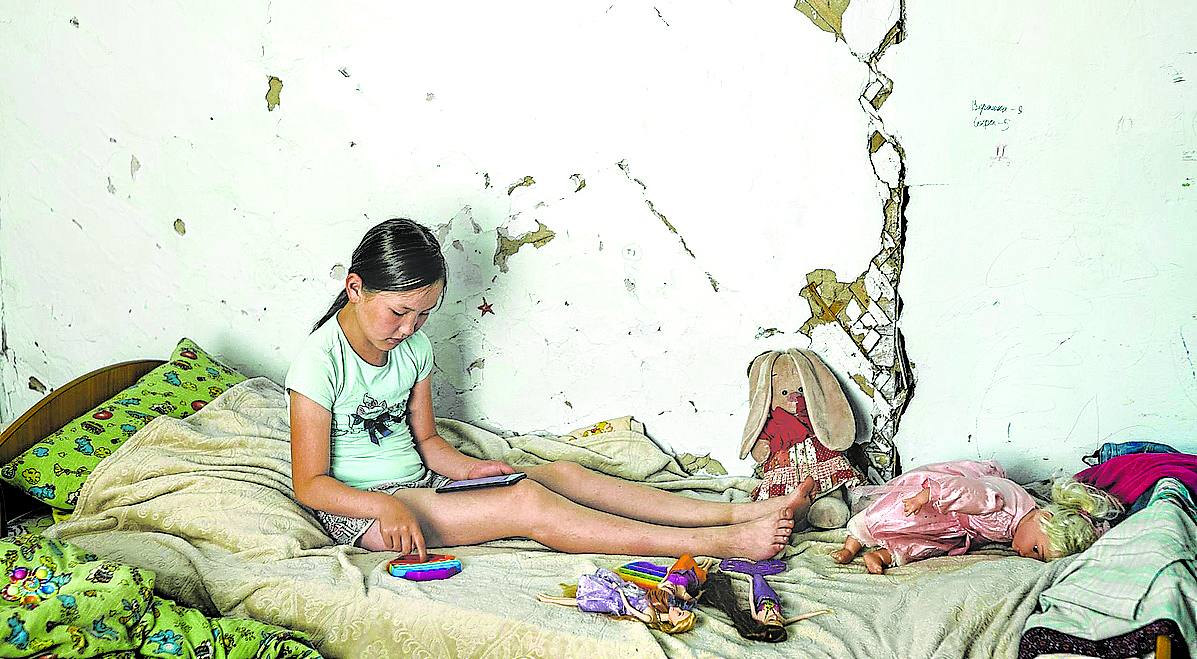 ‘As Frozen Land Burns’. Verónica está en su habitación en Yunkyur, en el sur de Sakha (Siberia, Rusia). Los incendios forestales, una grave contaminación por el humo y la degradación del permafrost están provocando el derrumbamiento de las casas, visible en las grietas de la pared. «Una mirada de la crisis climática que, en algunos lugares, atraviesa la vida cotidiana», resume el fotoperiodista de EL CORREO. 