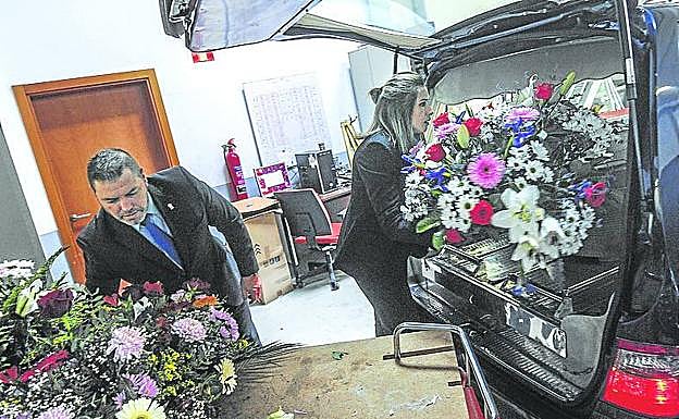 3. Javier y Neida colocan las flores en el coche fúnebre antes de realizar la conducción para un enterramiento.