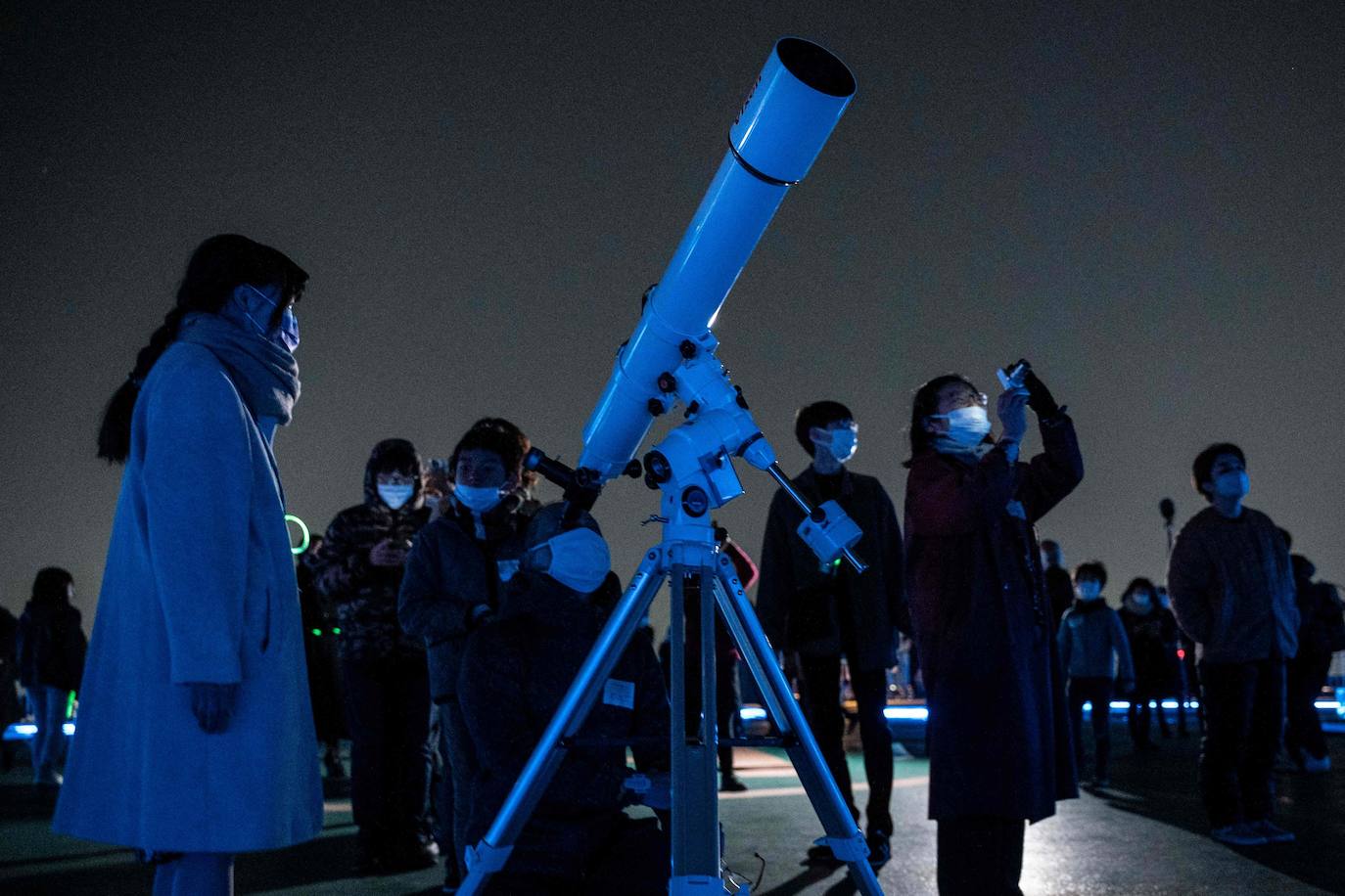 Varios jóvenes observan el eclipse desde Japón.