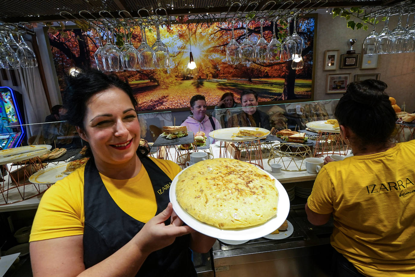 Ainara saca la tortilla a la barra del bar.