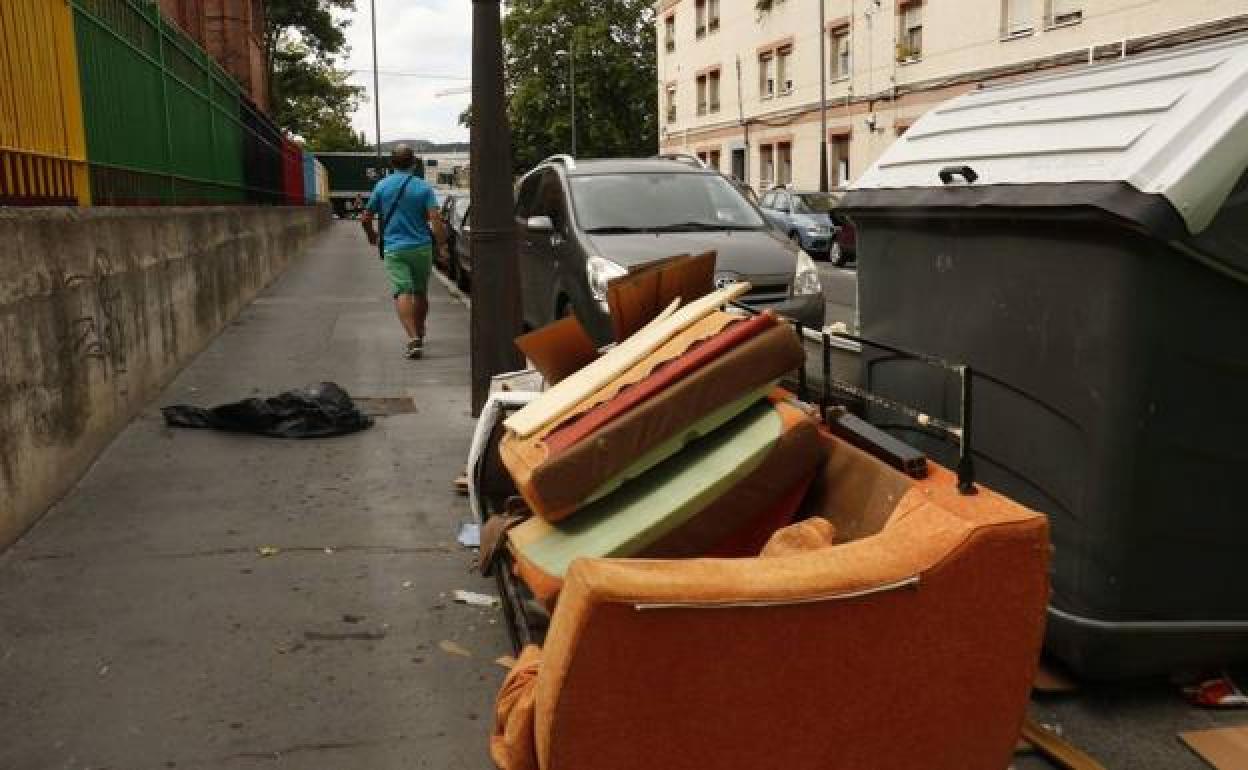 Un sofá abandonado junto a un contenedor en Campos de los Palacios, Adurza.