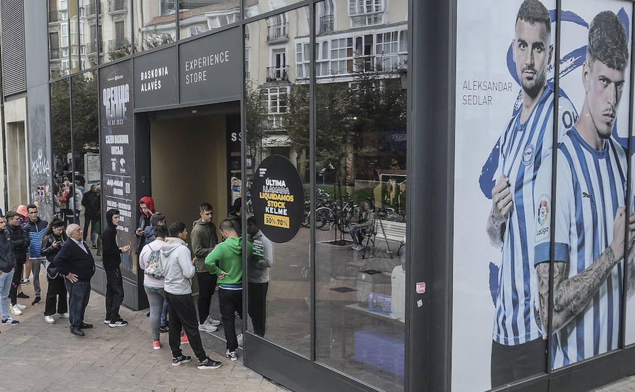 Aficionados hacen cola en la tienda del Alavés y el Baskonia en el centro de Vitoria.