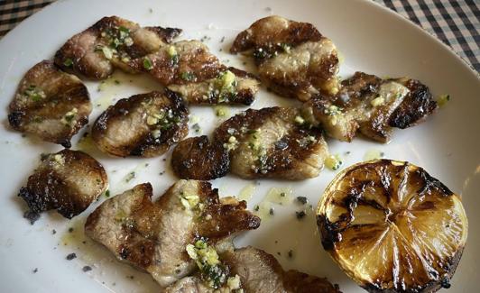 Mollejas de corazón de ternera con ajetes y limón asado.