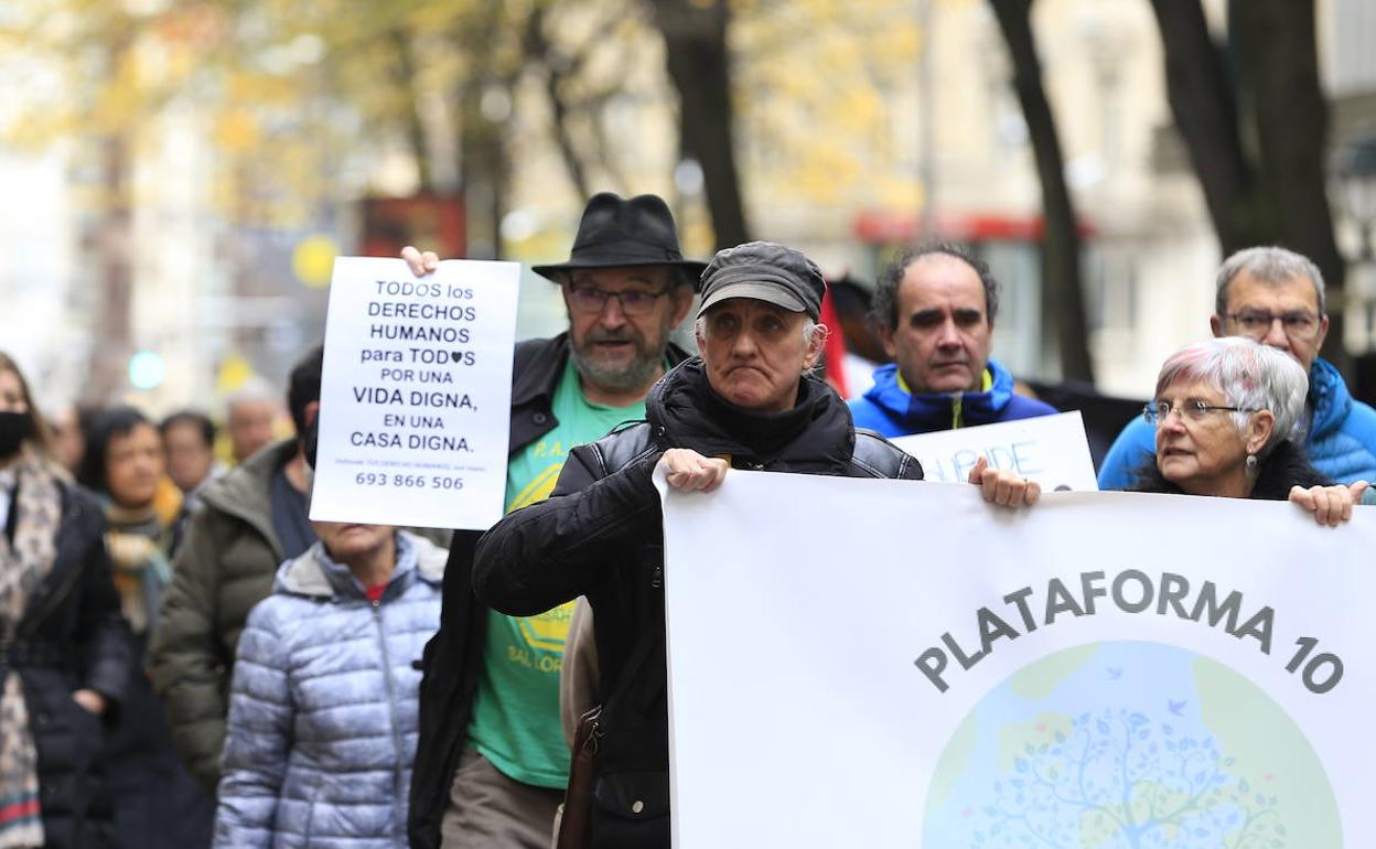 Un manifestante muestra un cartel reivindicativo mientras la protesta avanza por la Gran Vía. 