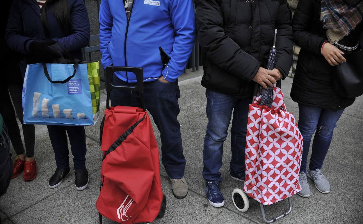 Varias personas esperan para recibir ayuda.