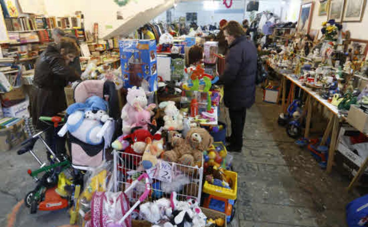 Varias personas revuelven ropa y juguetes en el rastrillo basauritarra. 